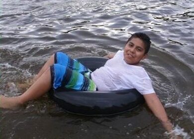 Boy in the pond in an inner tube