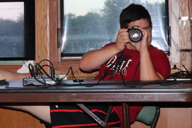 Young adult man focusing a camera