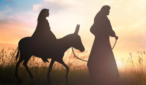 Silhouette of Mary riding a donkey with Joseph guiding